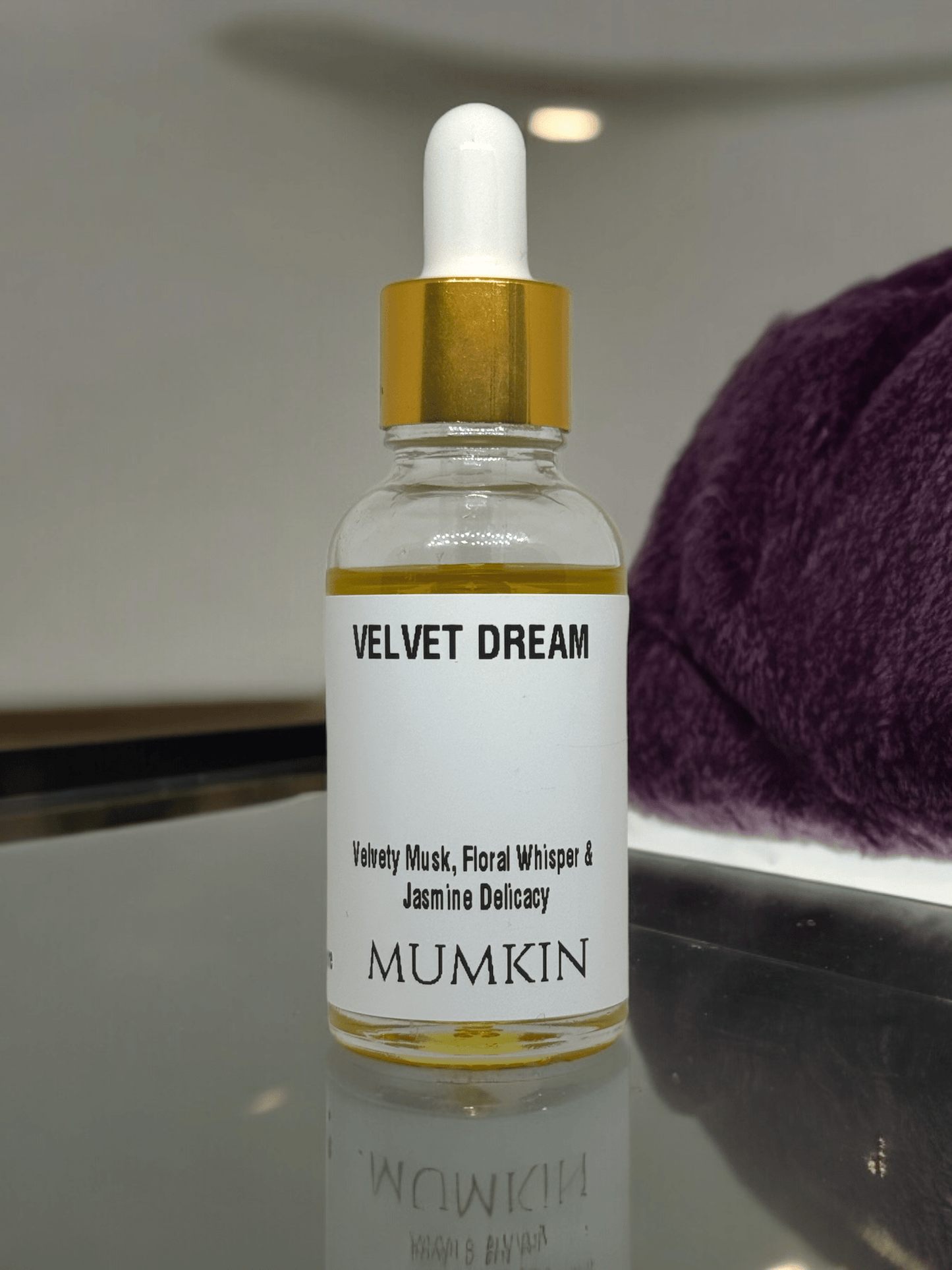 A 30ml glass dropper bottle labeled 'Velvet Dream' by Mumkin, featuring a gold cap and white label with black text. The fragrance notes include Velvety Musk, Floral Whisper, and Jasmine Delicacy. The liquid inside the bottle is golden yellow.