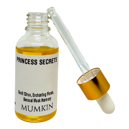 Close-up of a Princess Secrets fragrance oil bottle with a golden dropper and rich amber-colored liquid, featuring notes of sunlit citrus, enchanting florals, and sensual musk harmony by MUMKIN.