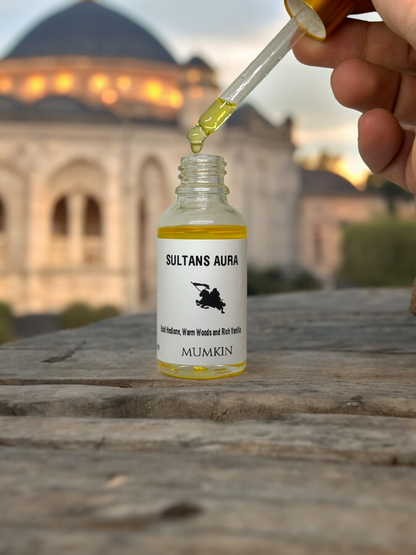 Sultan's Aura fragrance oil bottle with a dropper, set against a historic architectural backdrop.