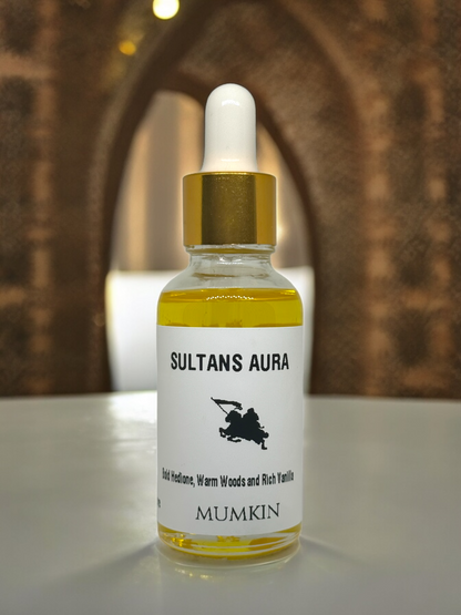 Sultan's Aura fragrance oil bottle with a golden dropper, displayed on a white surface against an arched architectural background.